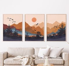 two paintings on the wall above a couch in a living room with a coffee table