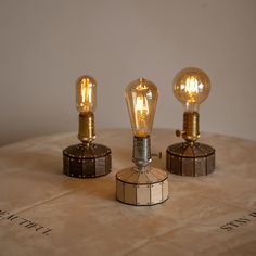 three light bulbs sitting on top of a table