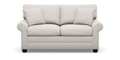 a white couch with two pillows on it's back and one arm facing the camera