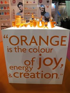 an orange is the color of joy and creation sign in front of a store display