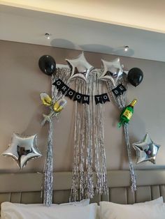 balloons and streamers in the shape of stars hang above a bed