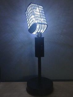 a lamp that is sitting on top of a wooden stand with a light in the shape of a microphone