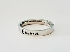 Petite name ring. Stacking name ring. Personalized name ring. This GOREOUS 3 mm ring is super shiny. Great for stacking.  The surface is flat, so the lettering really stands out!  Add names, initials, dates, quotes, roman numerals or scripture. I have the heart, double heart, infinity, #, &, @, !, =, *, :, ?, cross, baby foot, angel, and ribbon stamps. 15-character limit. Made of solid surgical Stainless steel which will never rust, tarnish, change color and is hypoallergenic.  Swim & shower saf Everyday Stackable Rings With Custom Name, Custom Name Adjustable Initial Ring For Promise, Minimalist Customizable Initial Ring For Promise, Minimalist Custom Name Adjustable Ring, Minimalist Customizable Initial Ring, Personalized Adjustable Stackable Rings, Adjustable Engraved Ring With Custom Name For Promise, Adjustable Engraved Promise Ring With Custom Name, Adjustable Engraved Ring With Custom Name For Everyday