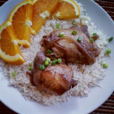 a plate with rice, oranges and chicken on it