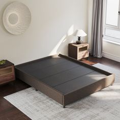 a bed sitting on top of a wooden floor next to a window