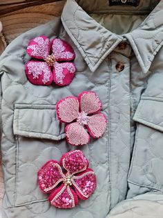 a jacket with pink flowers and sequins attached to it's back pocket