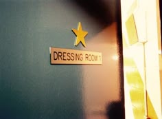 there is a sign that says dressing room on the wall next to a door with a star