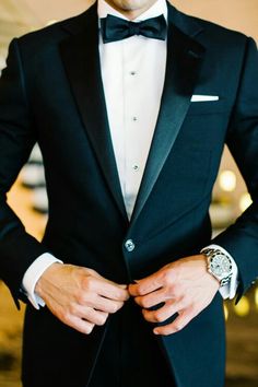 a man in a tuxedo is wearing a watch