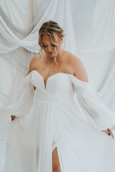 a woman in a white dress is posing for the camera