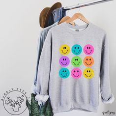 Hand-drawn smiley faces graphic tee design in a soft, cozy, sweatshirt. We hope you like it! * 50% cotton, 50% polyester * Pre-shrunk * Classic fit * 1x1 athletic rib knit collar with spandex * Air-jet spun yarn with a soft feel and reduced pilling * Double-needle stitched collar, shoulders, armholes, cuffs, and hem Refund/Exchange Policy: We do not accept returns or exchanges. Please refer to the sizing chart under the listed product to ensure you're selecting the best fit. Thank you! Boho Sweatshirt, Sweater Boho, Retro Sweater, Fall Tee, Fall Sweater, Graphic Tee Design, Winter Sweatshirt, Everyday Outfit, Sweater Women