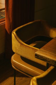 a wooden table with two chairs next to it and a window in the back ground