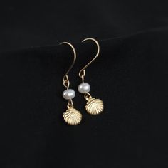 Who doesn't love pearls and seashells? These earrings combine the best of both worlds. You'll love the tiny shell charm and delicate freshwater pearl. A perfect gift for ocean lovers!   ABOUT: * Materials: 14k gold filled wire * Beads: real freshwater pearls and gold filled charm (one-sided, 7mm) * Earring wires: 22 gauge (.64mm) * Lightweight design * Sizing Details: (earring box is 2x3 inches for size reference) * Total Length: 1.25 in. (3cm) * Width: .25 in. (.5cm) SHOP OUR BRAND > https://ro Shell-shaped Pearl Earrings With Pearl Charm, Pearl Drop Shell As A Gift, Elegant Shell Pearl Earrings, Elegant Shell Dangle Jewelry, Ocean-inspired Pearl Drop Earrings As A Gift, Elegant Pearl Charm Earrings With Shell, Elegant Shell-shaped Earrings With Pearl Charm, Shell-shaped Pearl Earrings For Gift, Shell-shaped Pearl Drop Earrings For Gifts