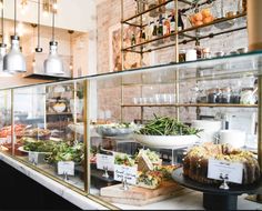 a display case filled with lots of different types of food on plates and trays