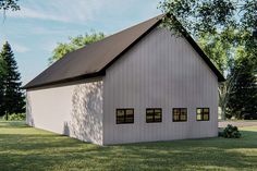 a large white barn sitting on top of a lush green field