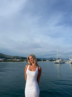 a woman in a white dress standing on a boat