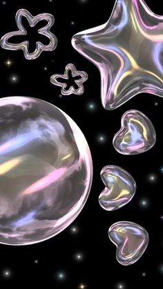 an image of some shiny objects in the air with stars and bubbles around them on a black background