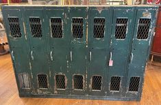 an old green metal storage cabinet with bars on the doors and holes in the sides