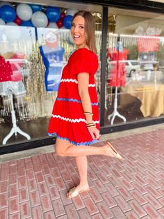 Be the cutest American gal in town with our American Cutie Mini Dress! Featuring white and blue ric rac details and a square neckline, this baby doll dress is perfect for any summer event. Say goodbye to boring outfits and hello to playful vibes with this dress! Key Features: Red with white & blue Ric Rac trim Square neck Puff Sleeves with elastic Mini Dress Pockets 100% Cotton Stylist Review: Model is 5'9" with a 34" bust and a 29" waist and usually wears a medium or large in tops. Model is pic Fun White Summer Dresses, Playful White Dress For Picnic, Fun Summer Holiday Dresses, Playful White Dress For Day Out, Cute Square Neck Mini Dress For Beach, Playful Cotton Mini Dress For Summer, Playful Mini Dress For Summer, Fun Short Sleeve Dresses For Day Out, Fun Mini Length Summer Dress