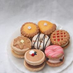 a white plate topped with lots of different types of cookies and pastries on top of each other