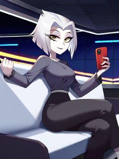 a woman sitting on top of a white couch holding a cell phone in her hand