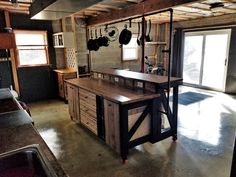 a kitchen with an island in the middle and pots hanging on the hooks above it