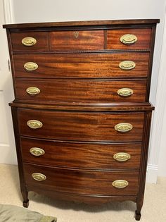 an antique chest of drawers with brass pulls and knobs on the bottom, in a bedroom