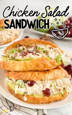 two chicken salad sandwiches stacked on top of each other with grapes and celery in the background