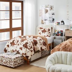 a bed room with two beds covered in brown and white blankets next to a window