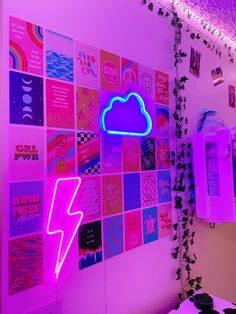 a room with pink and purple lighting, posters on the wall and a neon cloud