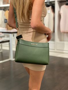 Faux leather 88.92% coated canvas/11.08% polyester Gold-tone hardware 10”W X 7”H X 3.5”D Adjustable strap: 22.5”-24.5” Interior details: back slip pocket, center snap pocket Lining: 100% polyester Green Faux Leather Crossbody Satchel, Green Crossbody Bag With Interior Card Slots, Chic Green Michael Kors Bag, Green Michael Kors Leather Bag, Green Crossbody Bag, Green Crossbody Box Bag With Gold-tone Hardware, Boutique Brands, Style Gift, Global Fashion