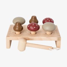 three wooden mushrooms sitting on top of a small table next to a toothbrush holder