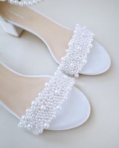 Classic satin block heel sandals adorned with allover pearls on the vamp and pearl ankle strap for romantic, elegant and feminine look. The delicate pearl beads are placed to create a graceful classic style. The light blue color can easily be your something blue. Simple and easy wear for bridal wear, bridesmaids, holiday party, wedding parties, and any special occasions. DETAILS:HEEL HEIGHT: 1.25 inches (kids) & 2 inches (women)COLORS AVAILABLE: White, Ivory, Light Blue, Champagne, Dusty PinkUPP Summer Wedding Pearl Heels, Pearl Embellished Block Heels For Wedding Guest, Wedding Guest Pearl Embellished Block Heels, Pearl Open Toe Wedding Shoes For Formal Occasions, Formal Open Toe Pearl Wedding Shoes, Elegant Pearl Embellished Open Toe Wedding Shoes, Formal Pearl Open Toe Wedding Shoes, White Pearl Embellished Wedding Shoes For Bridesmaids, Elegant Pearl-embellished Open Toe Wedding Shoes