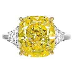 Immerse yourself in the enchanting radiance of this exquisite ring, adorned with a dazzling 4-carat Fancy Light Yellow cushion-cut diamond. The diamond's warm hue, paired with its internally flawless clarity, creates a mesmerizing play of light that captures the essence of pure elegance. Embracing the central gem are two trapezoid diamonds, skillfully cut to complement the cushion-cut centerpiece. These side stones add a contemporary flair to the design, enhancing the overall beauty of the ring Angie Crabtree, Fancy Yellow Diamond Ring, Radiant Diamond Rings, Radiant Cut Diamond Ring, Yellow Diamonds Engagement, Canary Diamond, Cushion Diamond Ring, Yellow Diamond Ring, Yellow Diamond Engagement Ring