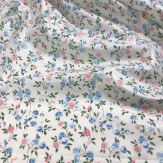 the fabric is white with blue and pink flowers on it