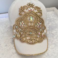 a white baseball cap with gold sequins on it's brim and beading