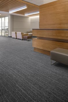 an empty room with wood paneling and gray carpet