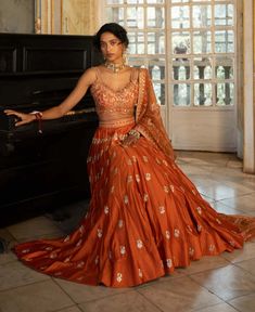 Editor's Note Introducing an exquisite rust heavily hand-embroidered lehenga set, paired with our signature printed organza-based dupatta. The intricate hand embroidery, featuring jaal, motifs, and highlighting borders, adds a touch of opulence and elegance to the ensemble. The rust hue exudes warmth and sophistication. Step into any special occasion with confidence, draped in this captivating rust lehenga set that effortlessly combines traditional craftsmanship with contemporary flair. Color: O Shadi Lehenga, Burnt Orange Lehenga, Rust Lehenga, Dupatta Draping, Orange Outfits, Orange Lehenga, Hindu Ceremony, Printed Organza, Desi Outfits