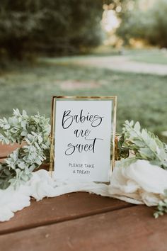 a sign that says bride are sweet on top of a table with flowers and greenery