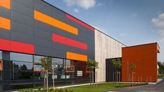 an orange and grey building with grass in front