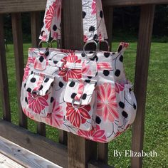 a handbag hanging on the side of a wooden fence with grass in the background