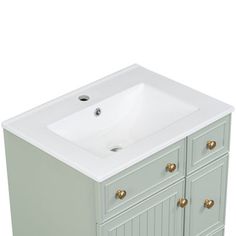 a white sink sitting next to a green cabinet