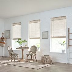 a white room with three windows and two chairs