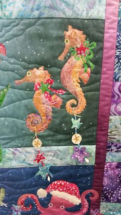 a quilted wall hanging with seahorses on it