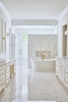 a large bathroom with marble floors and white walls, along with an oval bathtub