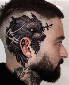 a man with tattoos on his face and behind the ear has a wolf head tattoo