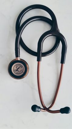 a stethoscope laying on top of a white table next to two black handles