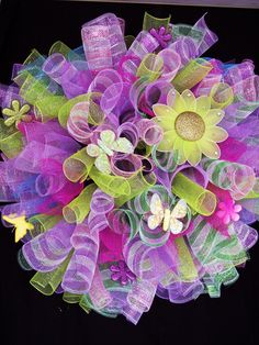 a purple and green wreath with butterflies on it