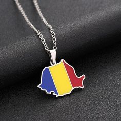 This pendant necklace features a map of Romania etched onto a delicate pendant. The pendant hangs from a dainty chain, making it the perfect accessory for those who love to travel or have a connection to a specific country. The intricate map design adds a unique touch to any outfit and is a meaningful way to show your pride for your heritage or favorite country. It is a perfect gift for travelers, expats, and anyone who wants to show off their love for a particular country. The pendant is made o Romania Map, Romania Flag, Pride Support, Flag Outfit, Delicate Pendant, Chain Making, Country Wear, Map Necklace, Country Maps