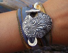 a close up of a person's arm wearing bracelets with an elephant on it