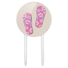 a pair of pink flip flops sitting on top of a white cake plate next to a toothpick